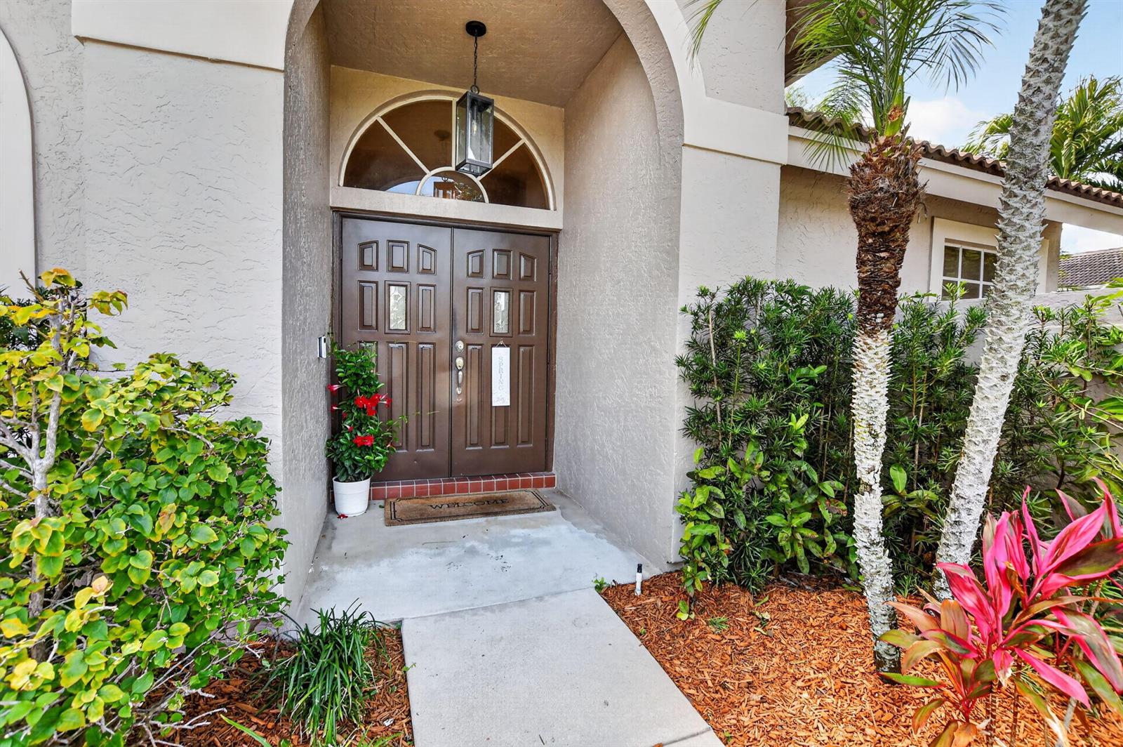 A front entrance features double brown doors under an arched transom window and a walkway — 18743 Cape Sable Drive, Boca Raton FL 33498, BOCA RATON, FL