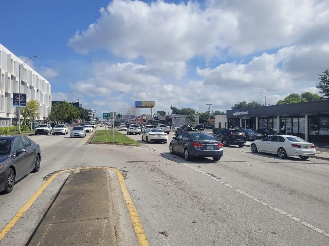 A street-level view shows cars driving on a multi-lane road lined with commercial buildings — 475 NW Le Jeune Rd, Miami FL 33126, MIAMI, FL