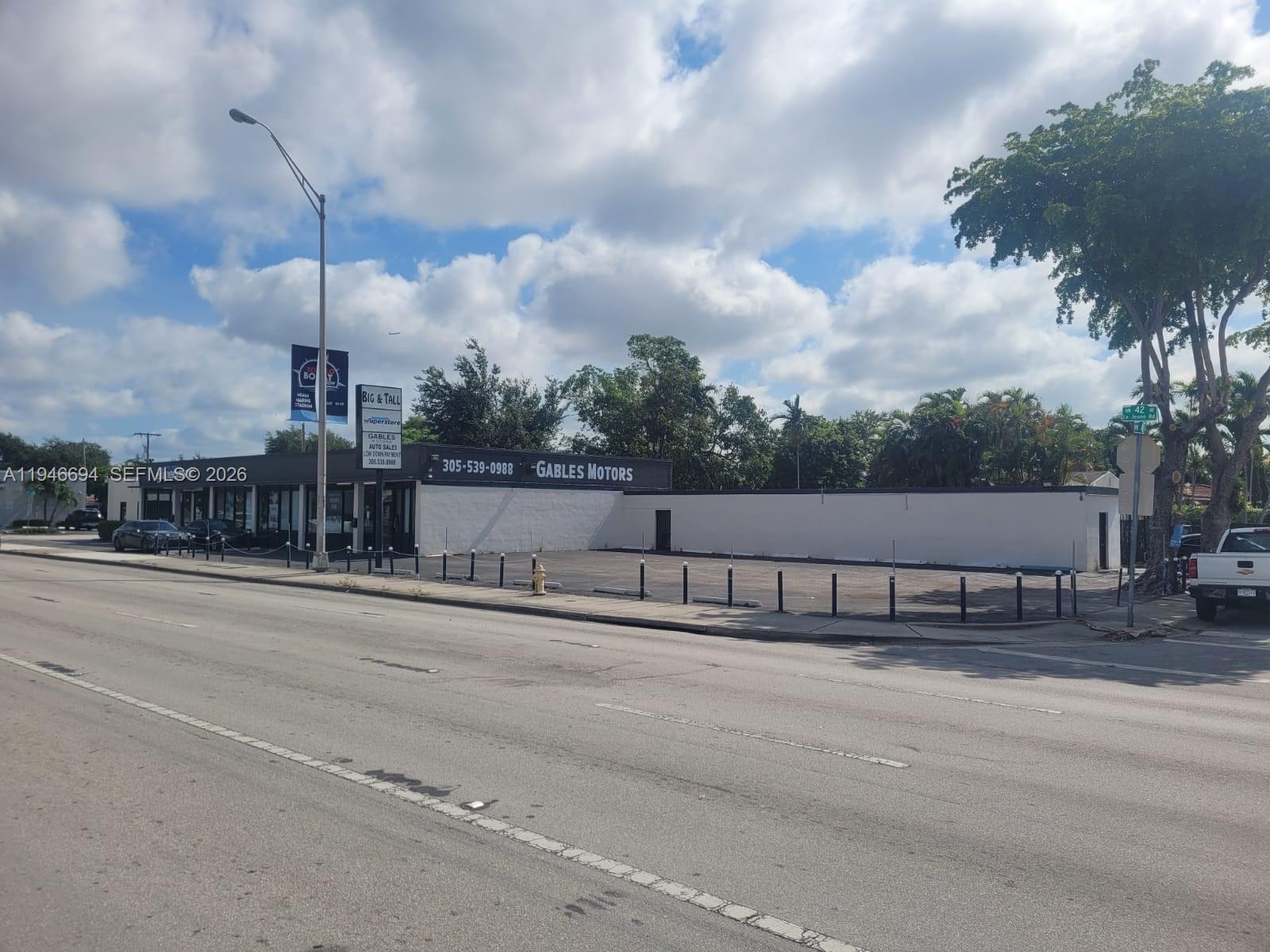 A commercial building with a large parking lot sits along a multi-lane road — 475 NW Le Jeune Rd, Miami FL 33126, MIAMI, FL