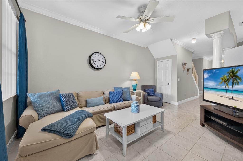 A living room features a beige sectional sofa, a white coffee table, and a television — 904 ASSEMBLY COURT, KISSIMMEE, FL