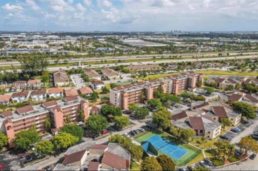 An aerial view of a residential apartment complex featuring a tennis court and nearby highway — 10253 NW 9th Street Cir # 6, Miami FL 33172, MIAMI, FL