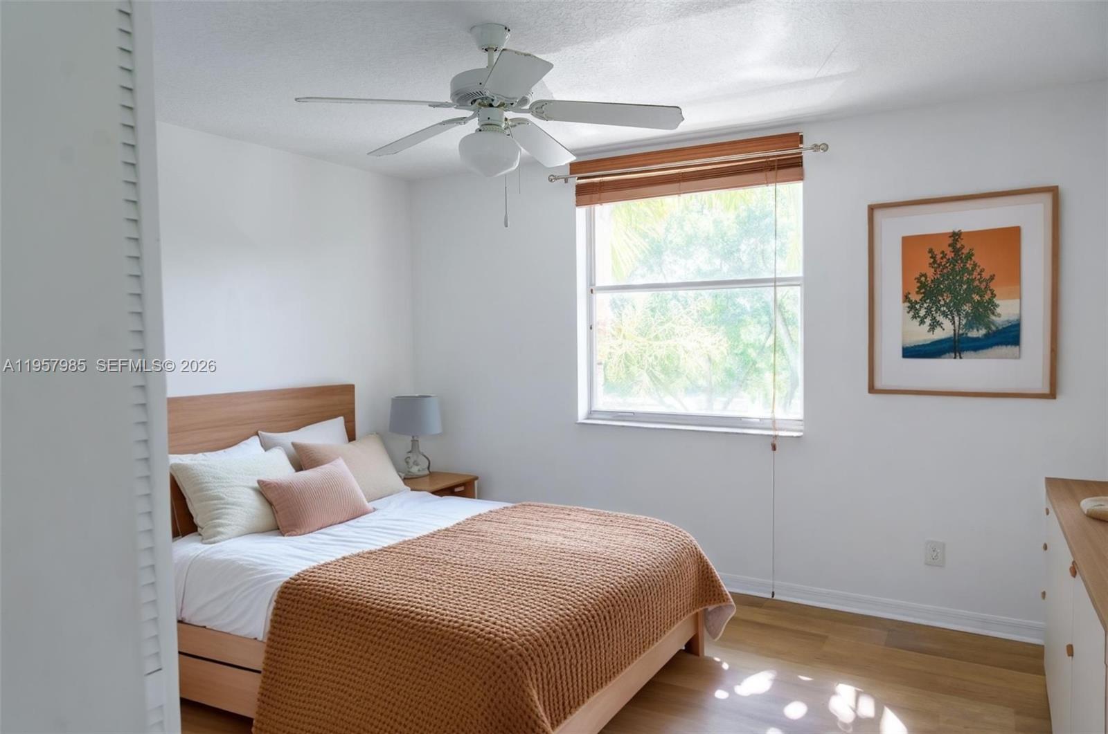 A bedroom features a bed with a brown knit throw, a ceiling fan, and window — 509 E Sheridan St # 3083, Dania Beach FL 33004, DANIA BEACH, FL