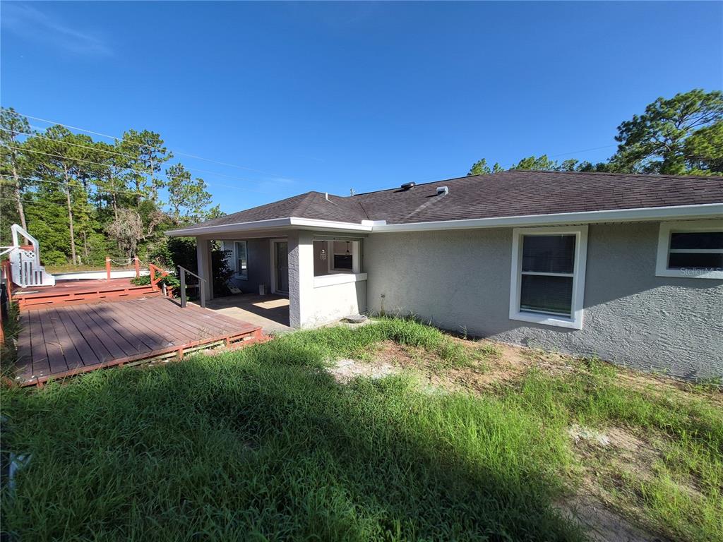 A single-story house with a white garage door and a concrete driveway under a blue sky — 1160 W GENEVA PLACE, CITRUS SPRINGS, FL