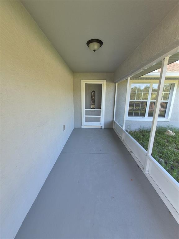 A gray house exterior features a wooden deck and a covered patio area — 1160 W GENEVA PLACE, CITRUS SPRINGS, FL