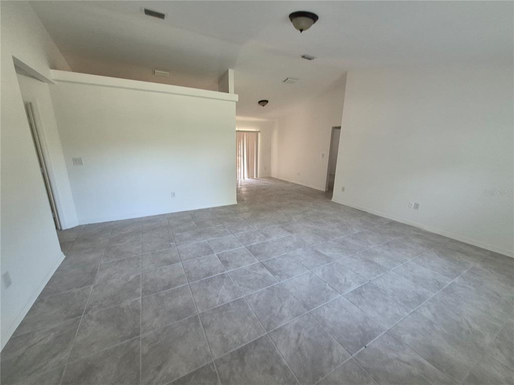 A covered, screened-in porch with a gray concrete floor and a white storm door — 1160 W GENEVA PLACE, CITRUS SPRINGS, FL
