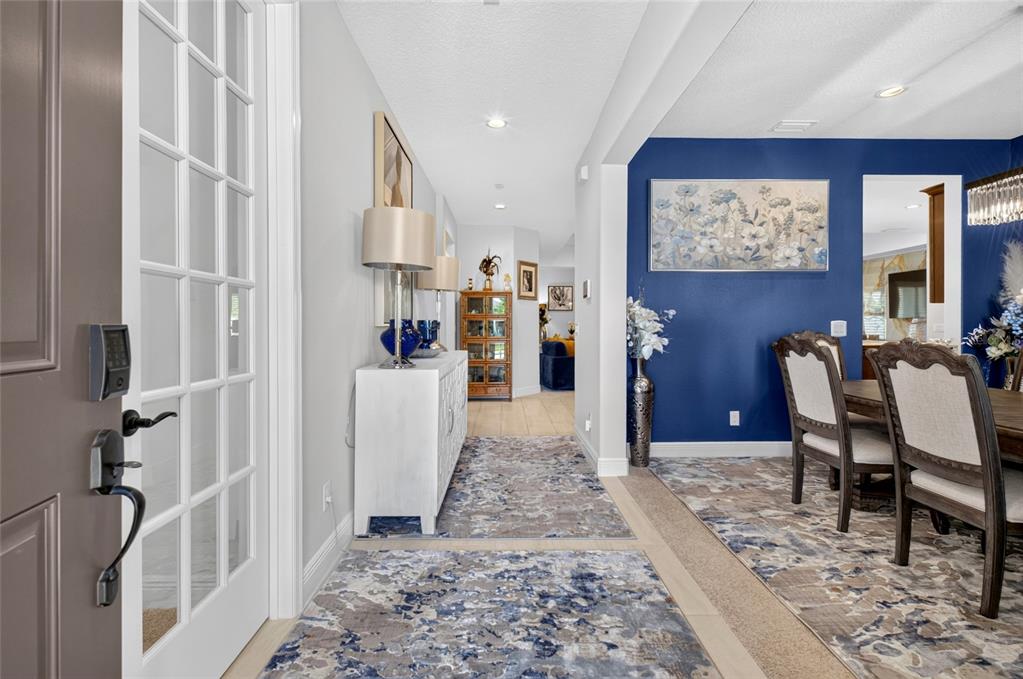 An entryway leads to a dining room with a blue accent wall and patterned rugs — 1325 BLARNEY STREET, CLERMONT, FL