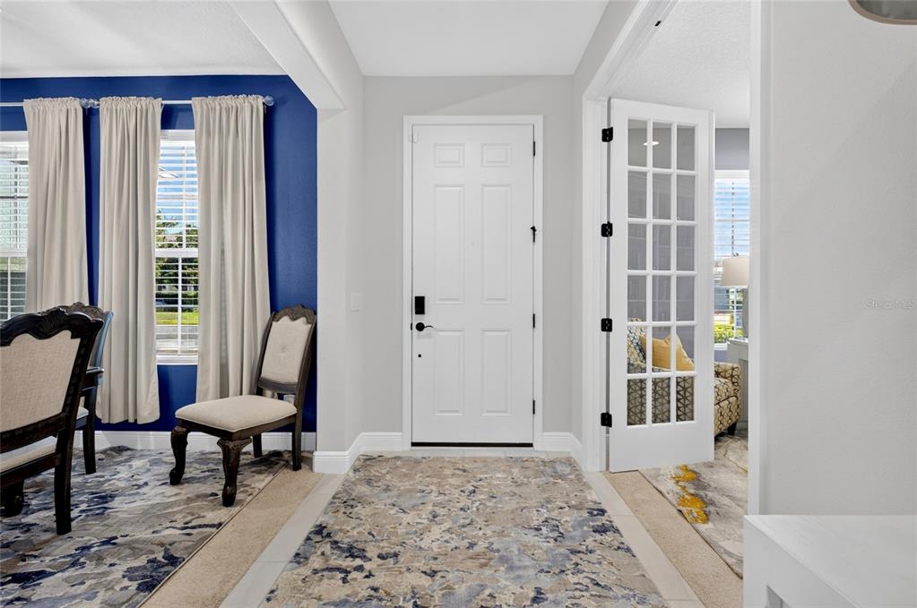 An entryway features a white front door, tiled floors, and a blue accent wall — 1325 BLARNEY STREET, CLERMONT, FL