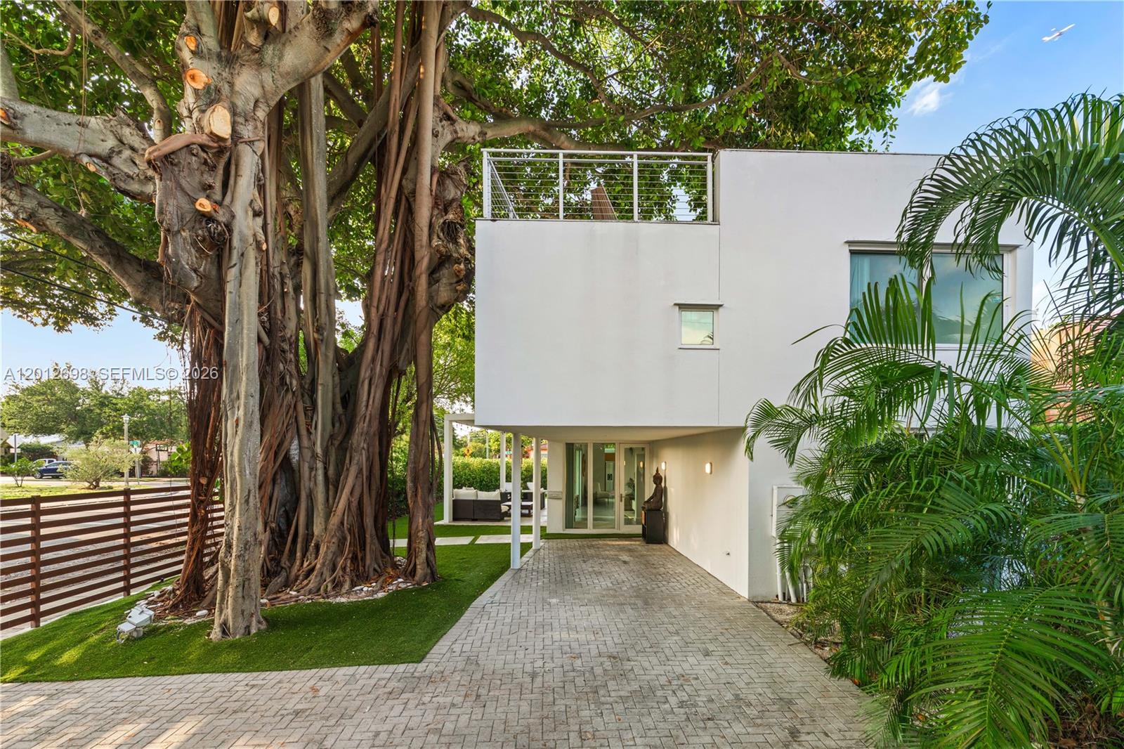 A modern white house features a large banyan tree and a paved driveway — 1898 SW 17th St, Miami FL 33145, MIAMI, FL