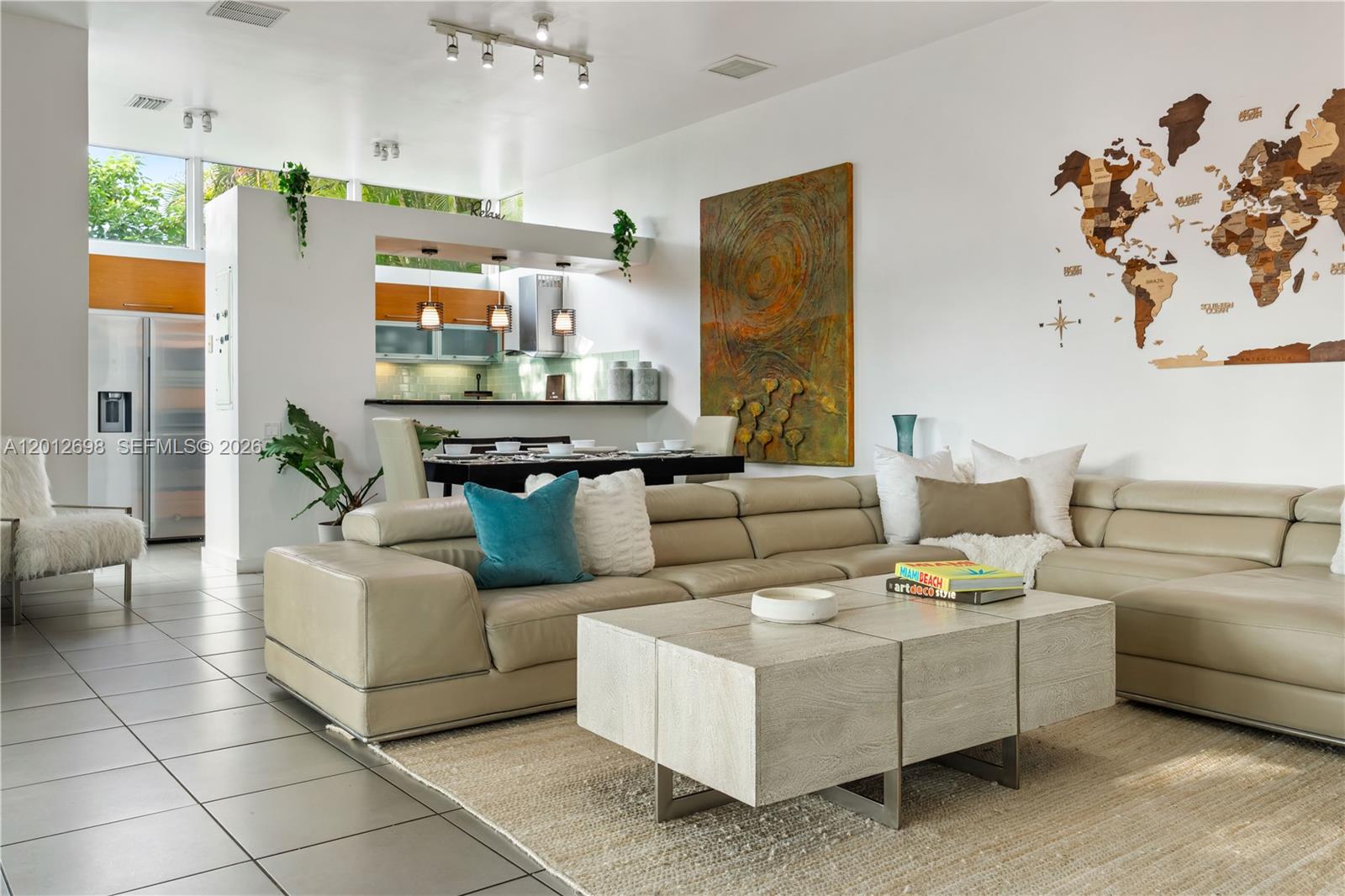 A modern living room features a large beige sectional sofa, a wooden coffee table, and a wall map — 1898 SW 17th St, Miami FL 33145, MIAMI, FL