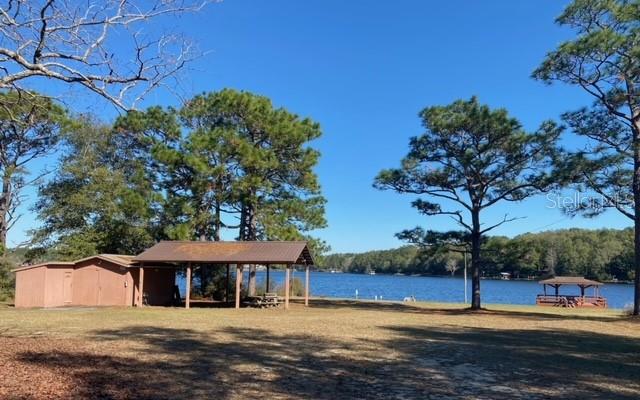 A lakeside park features a small storage building, a covered picnic pavilion, and a wooden dock — LOT 49 UNIT O&P, DEFUNIAK SPRINGS, FL