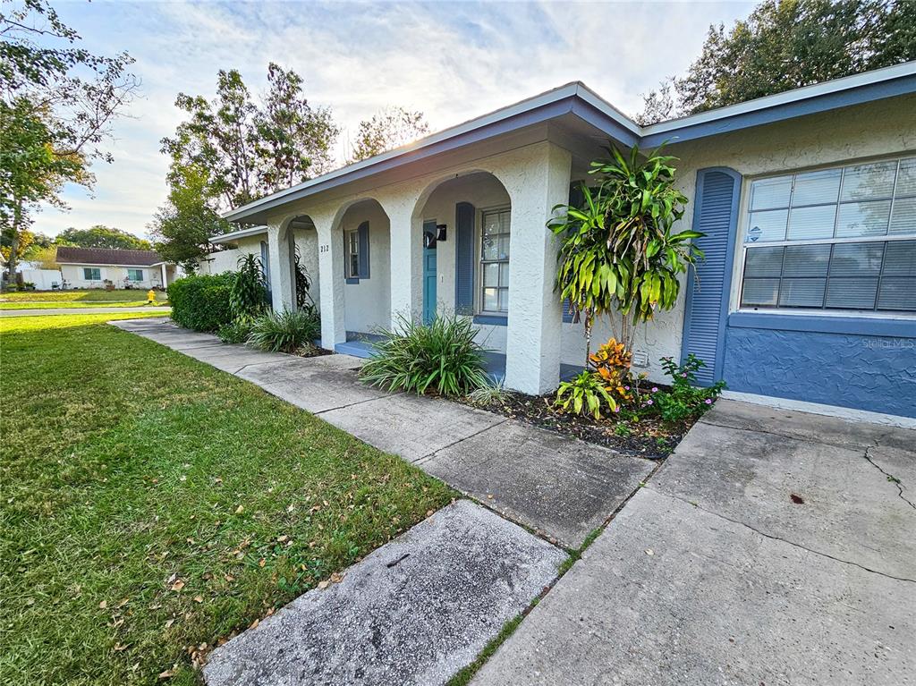 A single-story house with a stucco exterior, arched porch, and blue shutters — 212 S CORTEZ AVENUE, WINTER SPRINGS, FL
