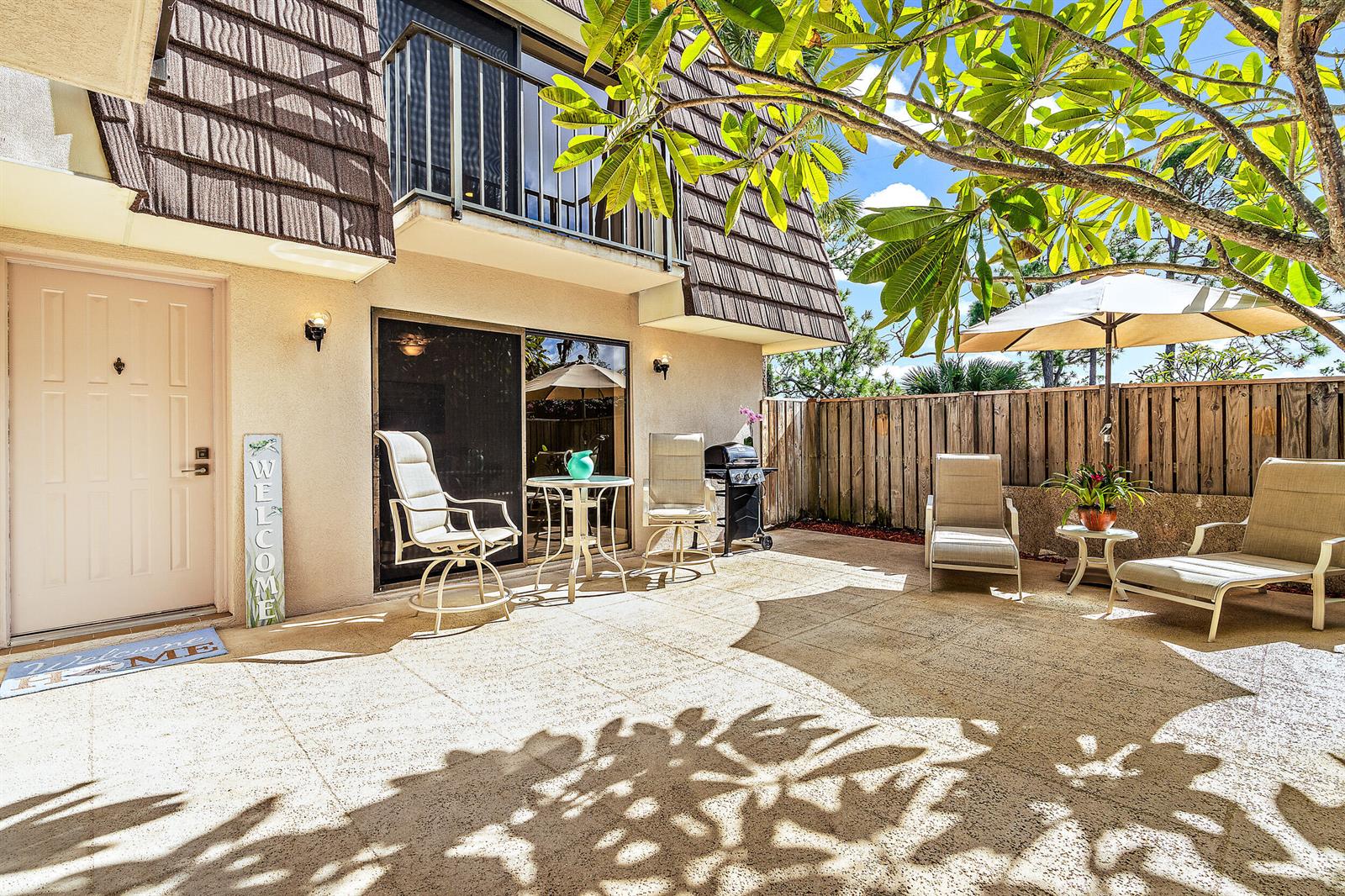 A patio with outdoor furniture and a grill sits outside a two-story residential building — 2316 23rd Court, Jupiter FL 33477, JUPITER, FL