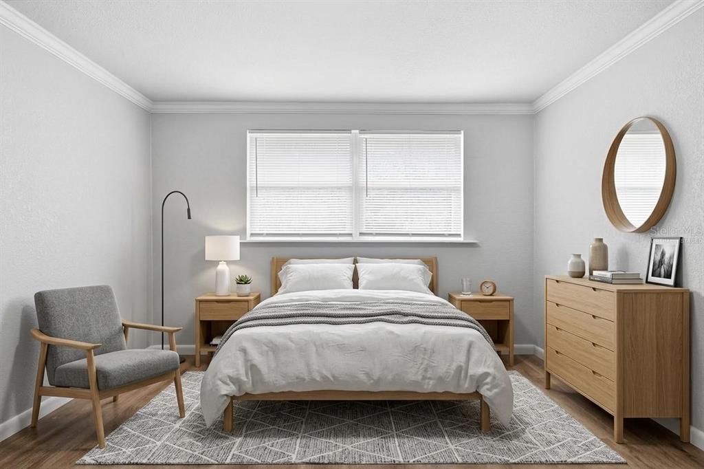 A bedroom features a bed, two nightstands, a dresser, an armchair, and a circular mirror — 8531 HORIZON LANE, HUDSON, FL