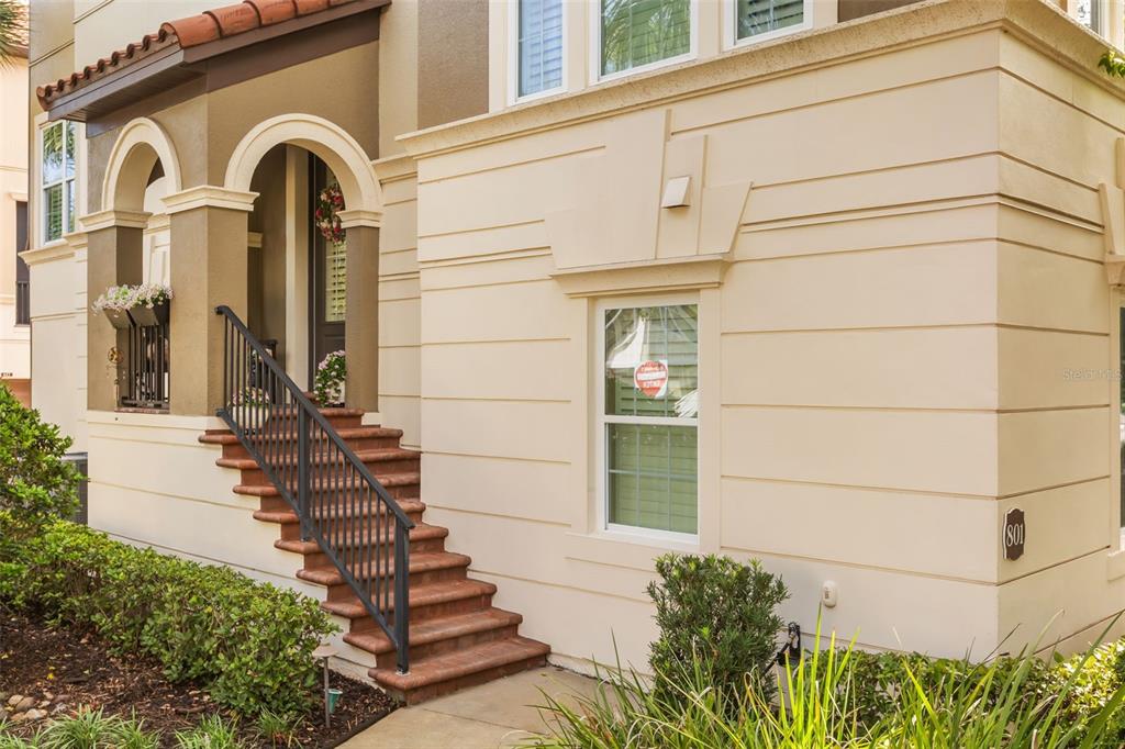 A tan exterior of a multi-story building featuring a staircase leading to an arched entryway — 801 LOBELIA DRIVE, LAKE MARY, FL