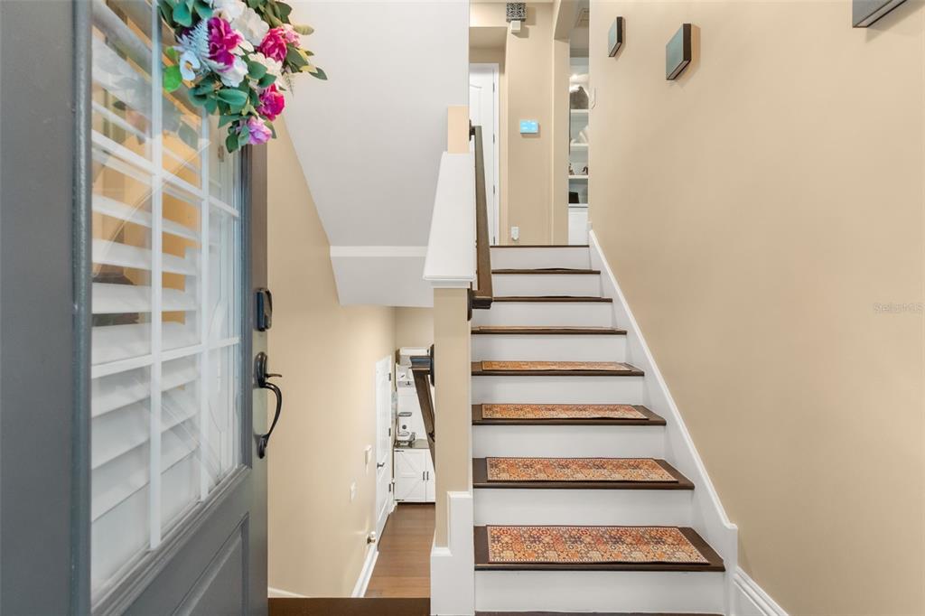 A staircase with patterned treads leads upward beside a doorway and a small hallway — 801 LOBELIA DRIVE, LAKE MARY, FL