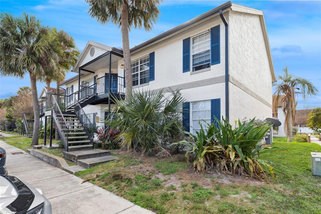 A two-story apartment building with white stucco walls, blue shutters, and an exterior metal staircase — 3651 N GOLDENROD ROAD UNIT 110, WINTER PARK, FL