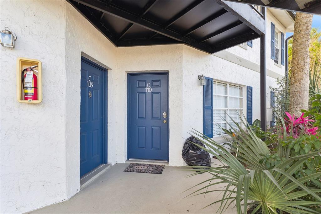 The exterior view shows two blue apartment doors labeled C109 and C110 with a fire extinguisher — 3651 N GOLDENROD ROAD UNIT 110, WINTER PARK, FL