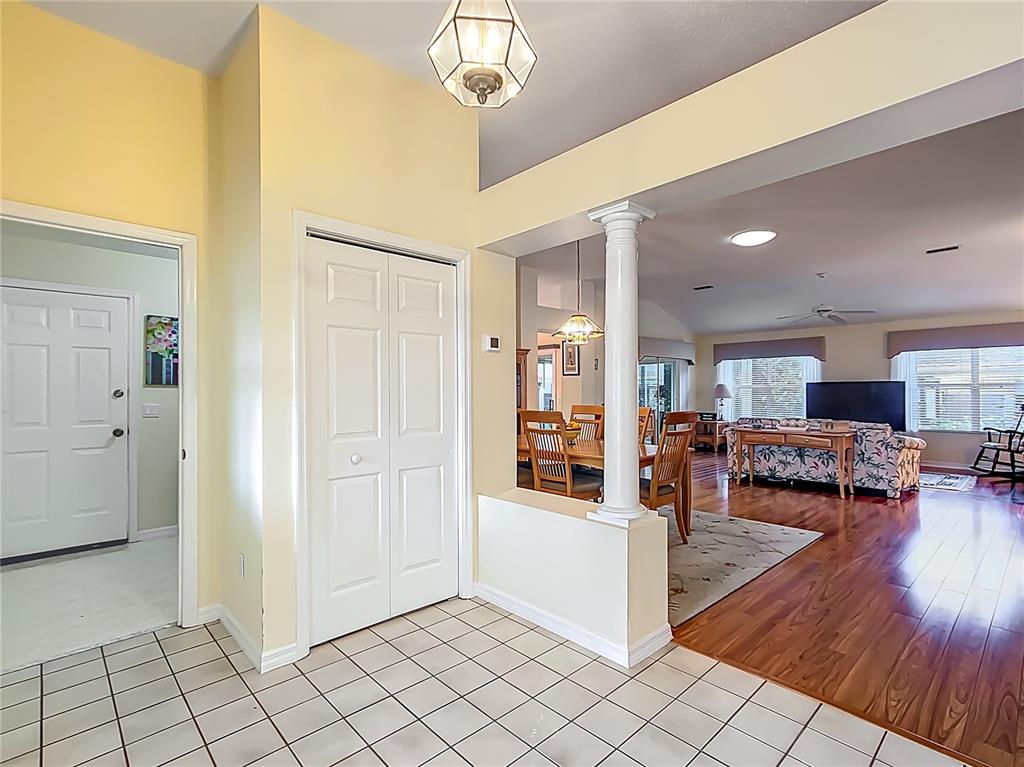 A tiled entryway leads to a dining area and living room with hardwood flooring — 208 DESOTA COURT, LADY LAKE, FL