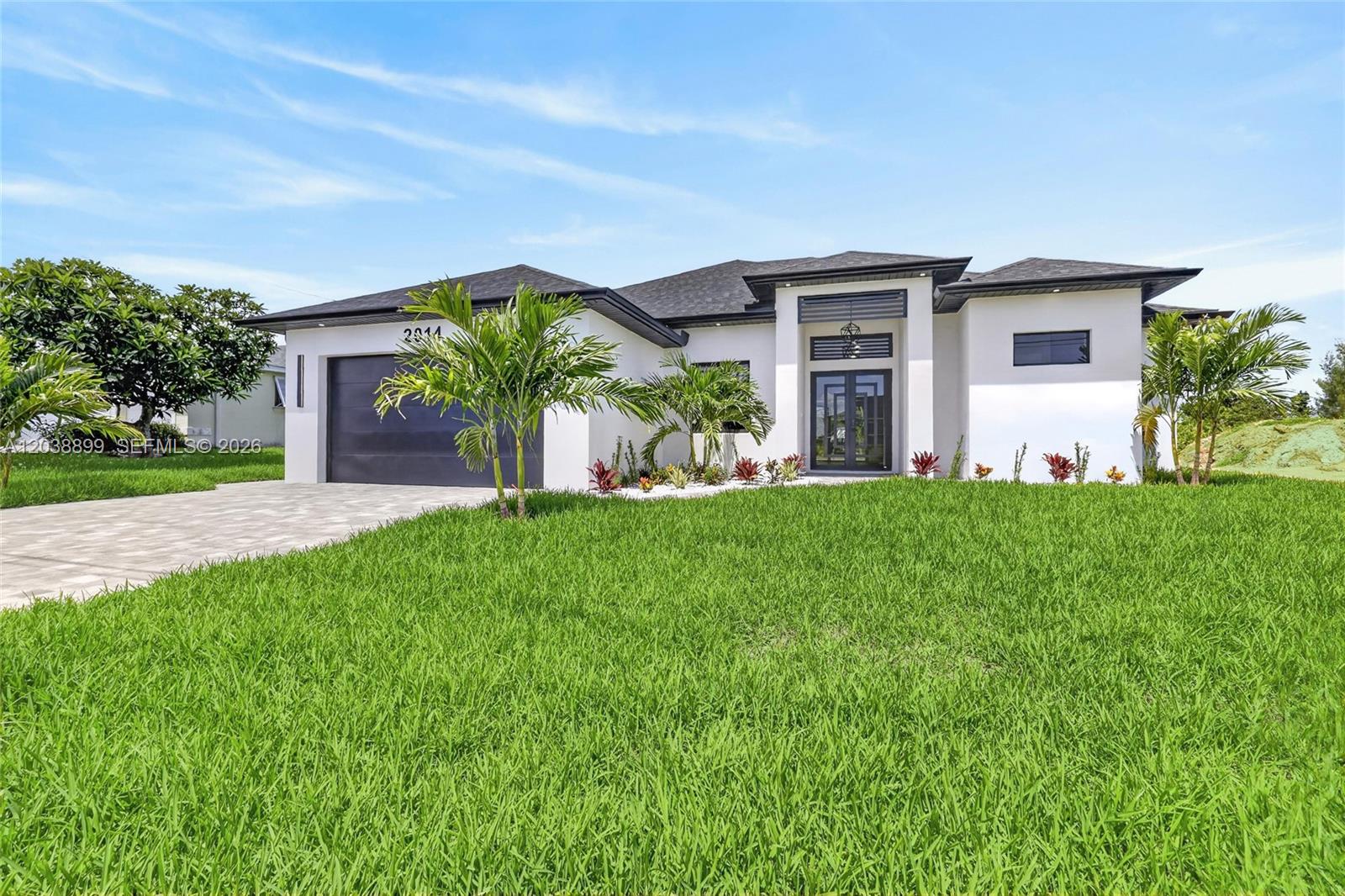 A modern, single-story white house with a dark roof and a paved driveway — 2014 SW 8th PL, Cape Coral FL 33991, CAPE CORAL, FL