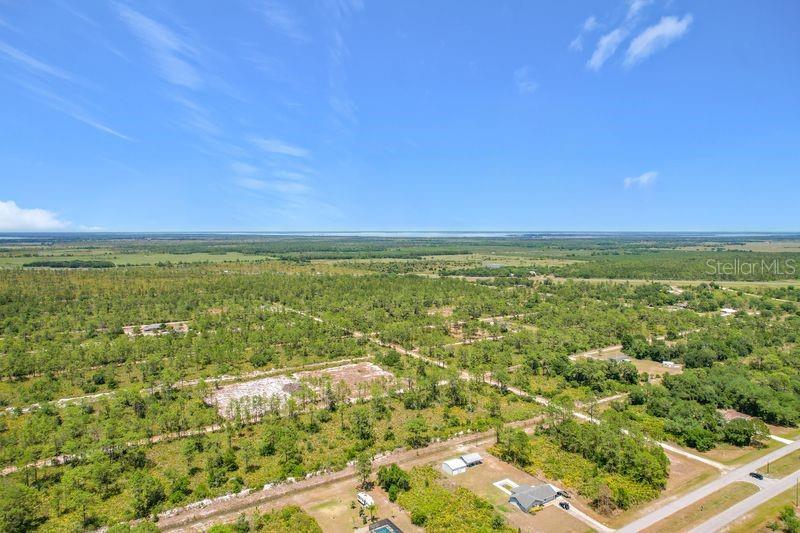 An aerial view shows a large, undeveloped plot of land with scattered trees and vegetation — 0 EL DORADO DRIVE, INDIAN LAKE ESTATES, FL