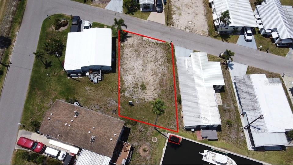 An aerial view shows a vacant rectangular lot outlined in red between two houses — 292 NASSAU DRIVE, PALMETTO, FL