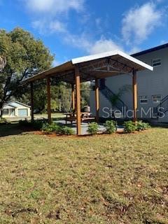 A wooden pavilion with a metal roof stands over a picnic table in a yard — 1002 E MCDONALD AVENUE UNIT 3, EUSTIS, FL