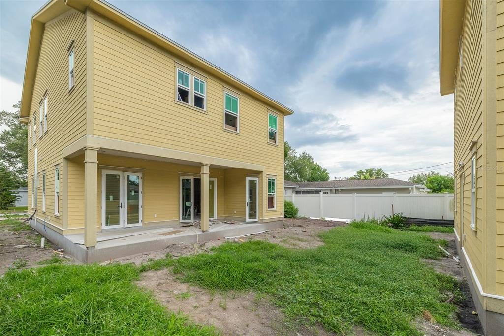 The exterior of a yellow two-story house with a covered patio and a grassy yard — 3320 15TH STREET N, ST PETERSBURG, FL