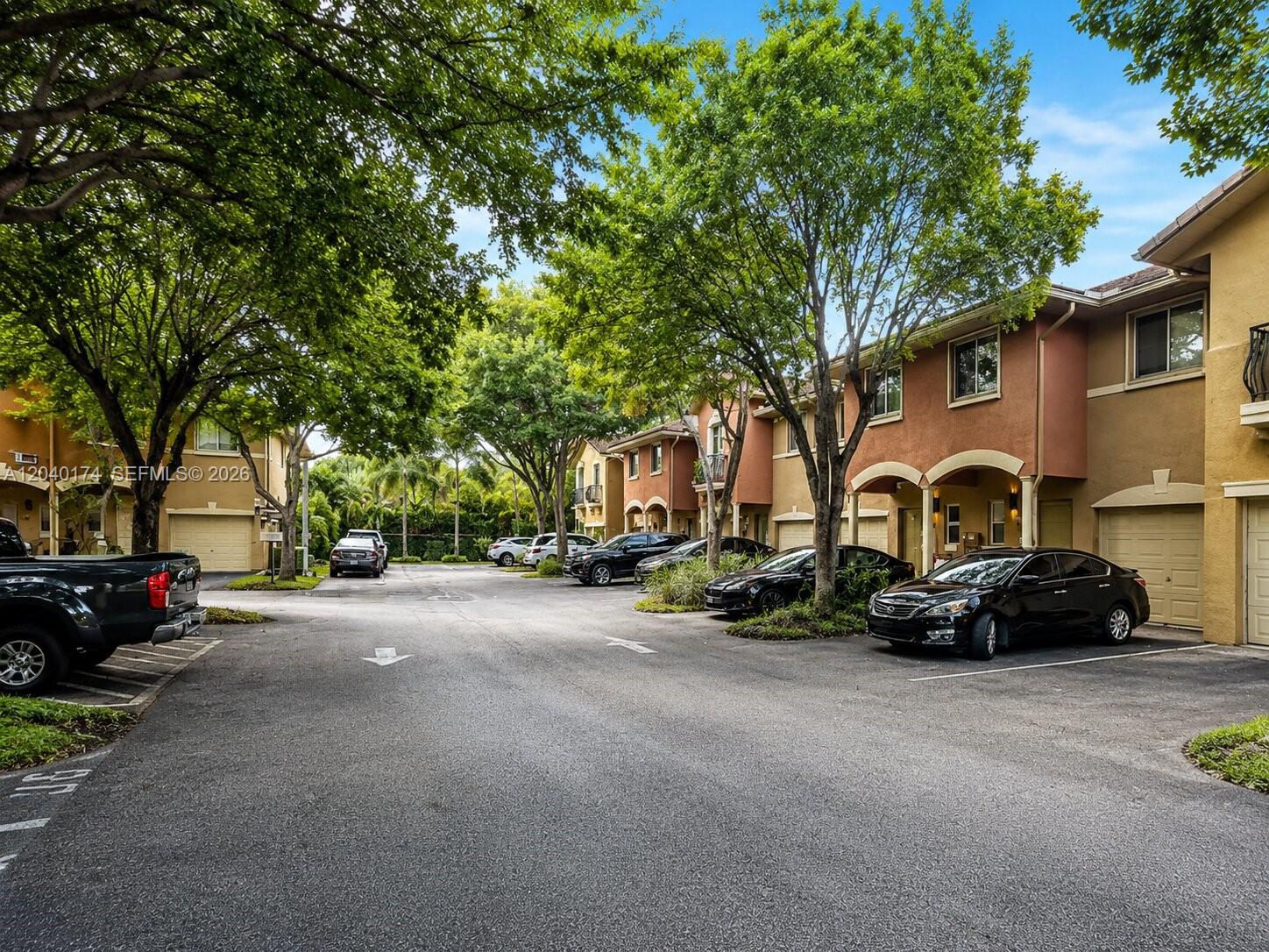 A paved parking area sits in front of a row of two-story townhouses with trees — 31 SE 3, Hallandale Beach FL 33009, HALLANDALE BEACH, FL