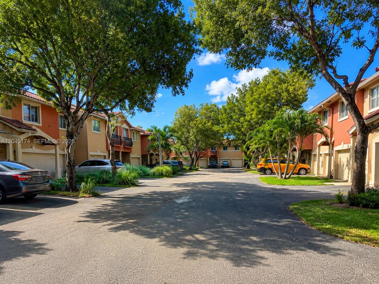 A paved driveway leads between two rows of multi-story residential townhomes with attached garages — 31 SE 3, Hallandale Beach FL 33009, HALLANDALE BEACH, FL