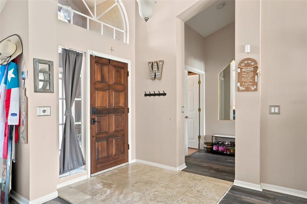 An entryway features a wood front door, tile flooring, and a hallway leading to another room — 10296 WINDSOR COURT, SPRING HILL, FL