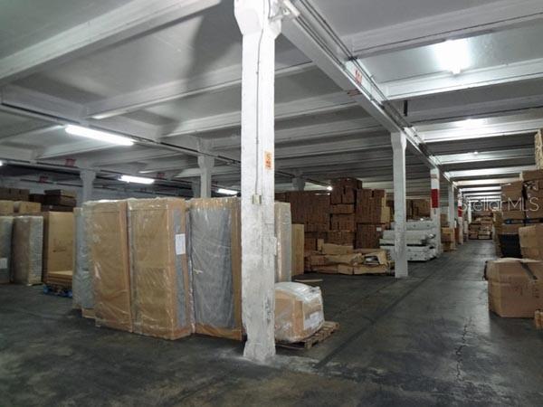 A large, open warehouse space with concrete floors, support columns, and stacked inventory boxes — Constitucion Ave INT PR-27, SAN JUAN, PR