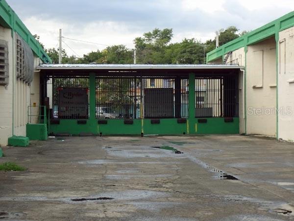 An exterior view of a commercial building with a gated loading dock area and concrete pavement — Constitucion Ave INT PR-27, SAN JUAN, PR