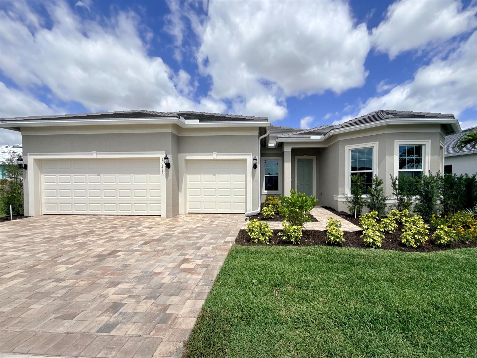 A single-story house with a beige exterior, a paved driveway, and a two-car garage — 10470 SW Highpointe Drive # 127, Stuart FL 34997, STUART, FL