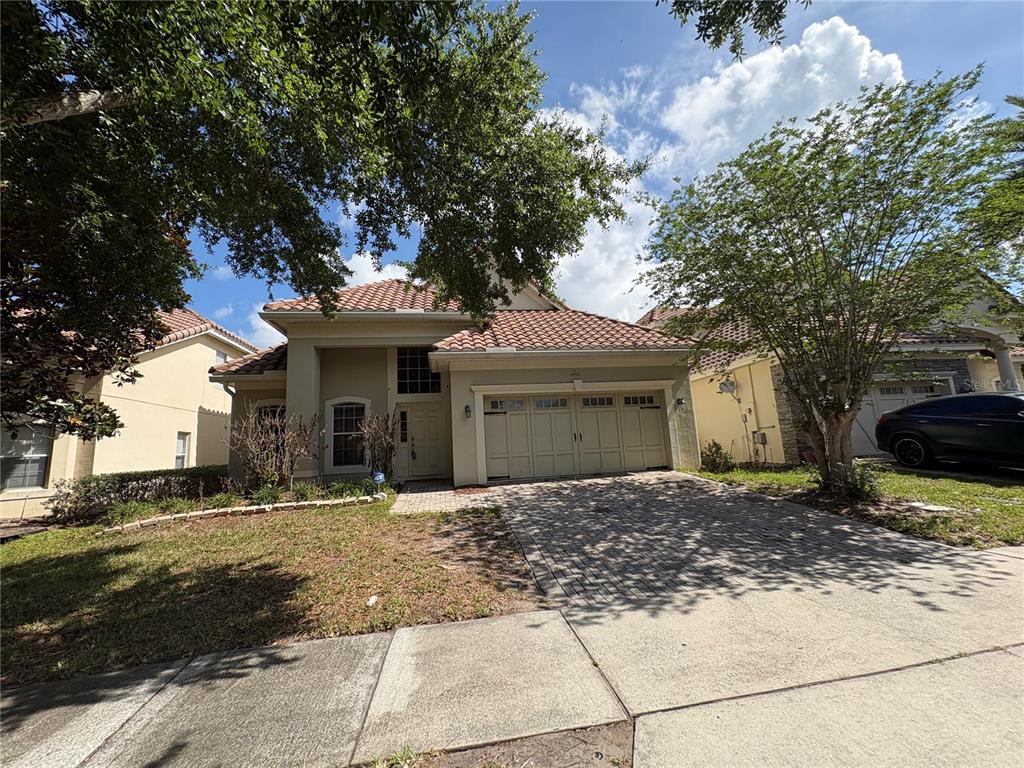 A single-story house with a tiled roof, a two-car garage, and a paved driveway — 6931 LUCCA STREET, ORLANDO, FL