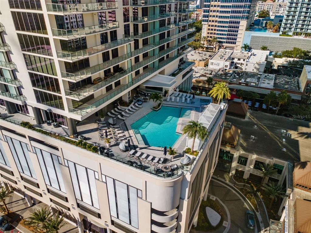 An aerial view of a high-rise building featuring a rooftop swimming pool and lounge area — 275 1ST AVENUE S UNIT 2308, ST PETERSBURG, FL