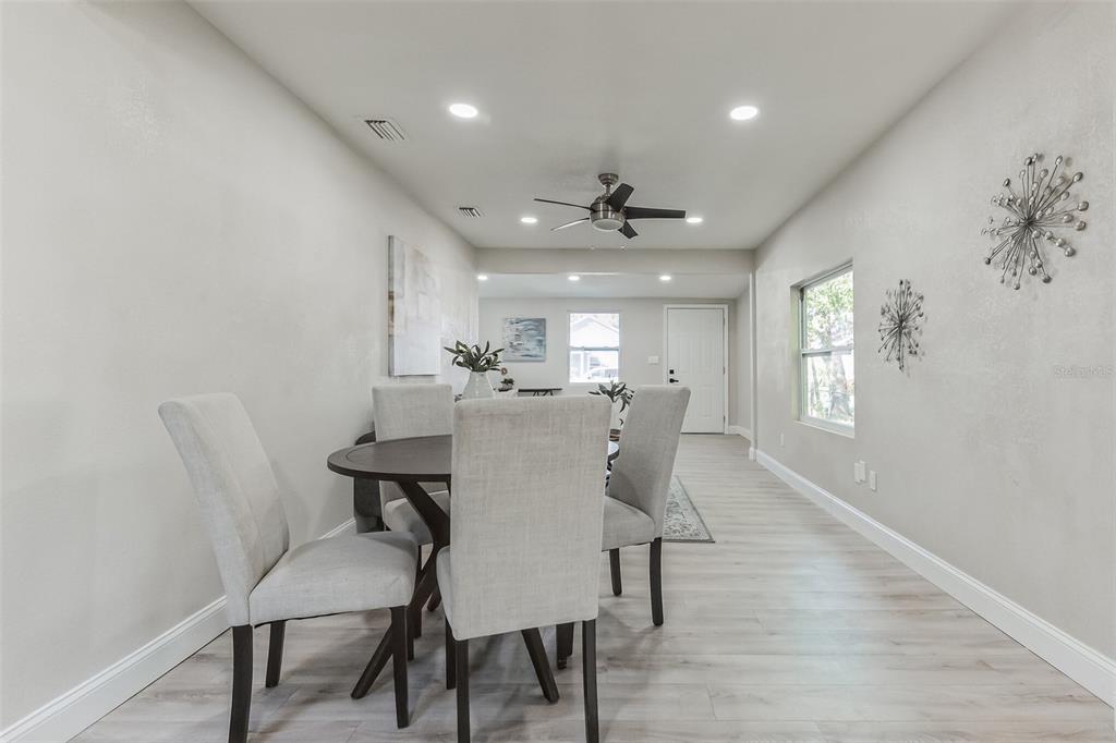 A dining area features a round table with four chairs, light flooring, and recessed lighting — 3458 QUEENSBORO AVENUE S, ST PETERSBURG, FL
