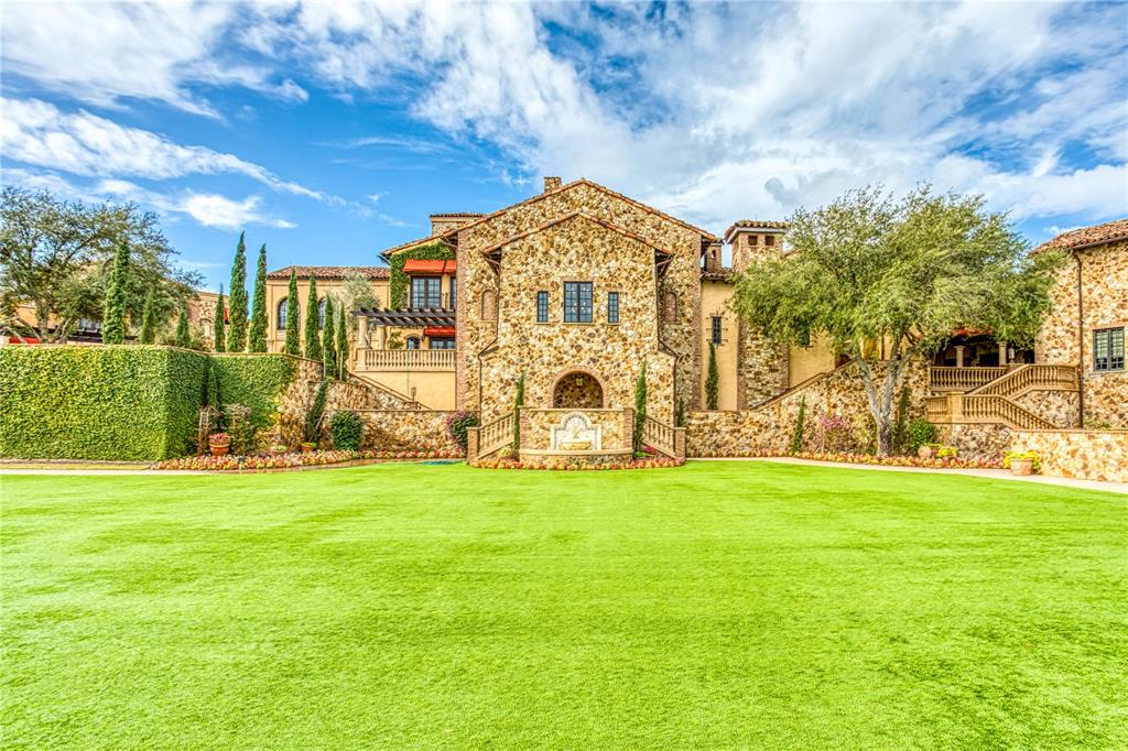 A large stone mansion features a central fountain and a sprawling green lawn — 15910 VETTA DRIVE, BELLA COLLINA, FL