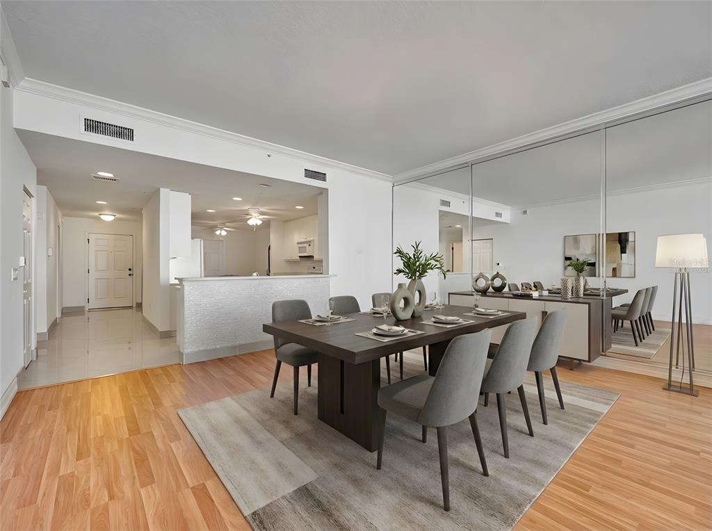 A dining room with a dark wood table, gray chairs, and a mirrored wall — 5 INDIAN RIVER AVENUE UNIT 1204, TITUSVILLE, FL