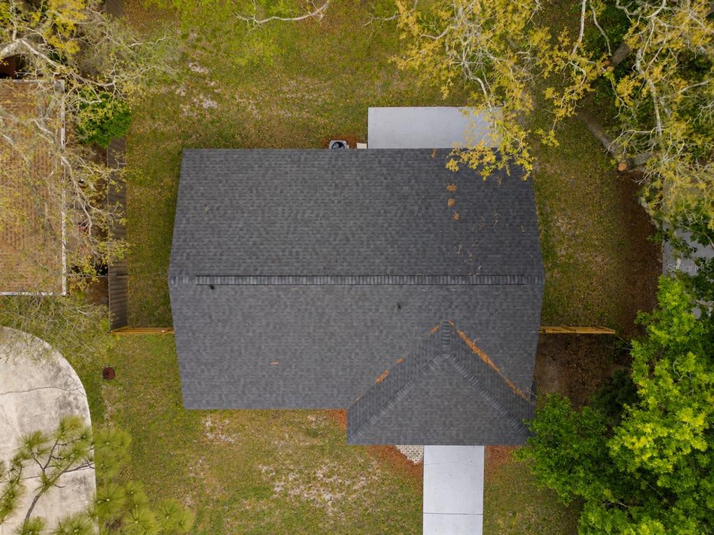 An aerial view shows the dark shingled roof of a house surrounded by a grassy yard — 821 OSCEOLA TRAIL, CASSELBERRY, FL