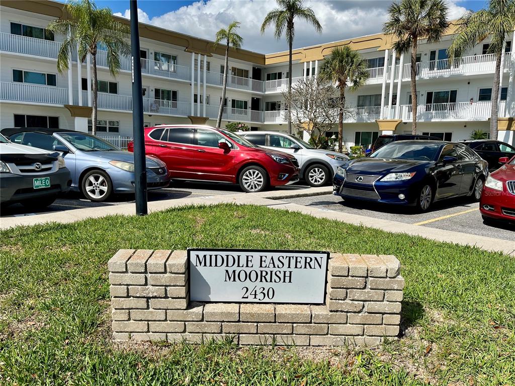 A brick sign for Middle Eastern Moorish stands in front of a multi-story apartment building — 2430 BRAZILIA DRIVE UNIT 44, CLEARWATER, FL