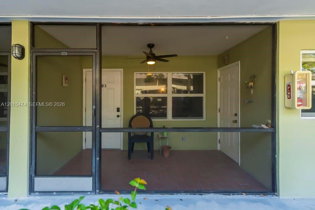 A covered patio features a screen enclosure, tile flooring, a ceiling fan, and two doors — 1425 Arthur St # 103A, Hollywood FL 33020, HOLLYWOOD, FL