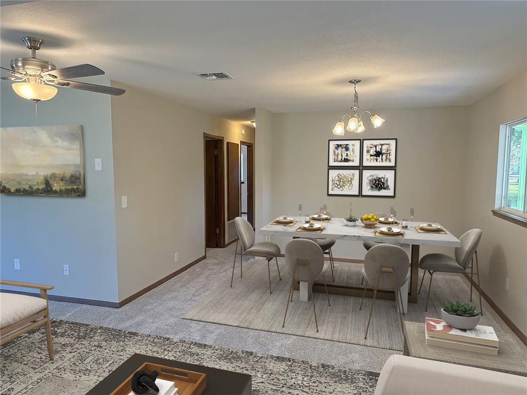 A dining area with a marble-topped table and chairs sits adjacent to a living room — 9095 SW 104TH LANE, OCALA, FL