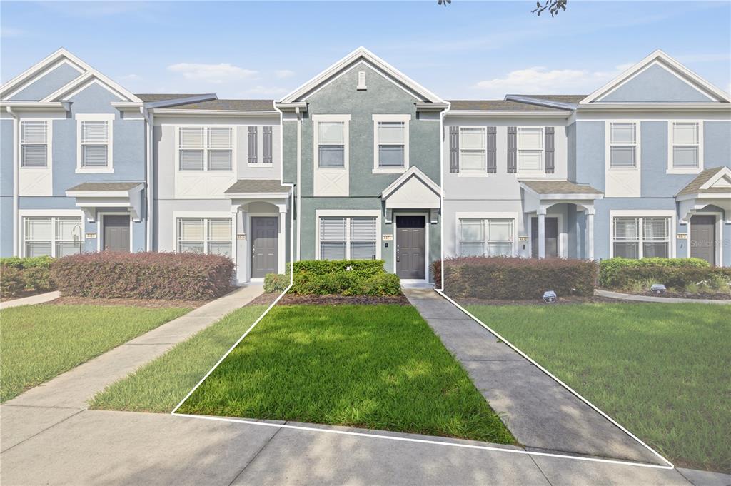 A multi-story townhouse exterior features a blue facade, a front lawn, and a concrete walkway — 4471 SW 49TH AVENUE, OCALA, FL