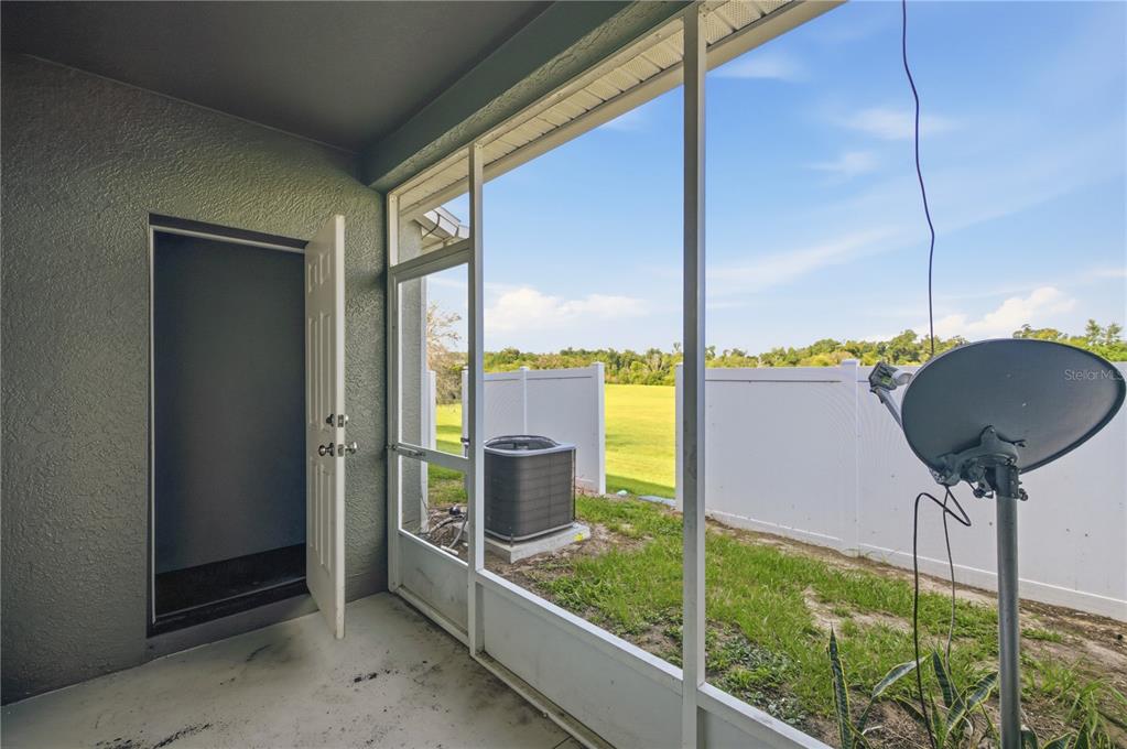 A screened-in porch with a door leading inside, an air conditioning unit, and a satellite dish — 4471 SW 49TH AVENUE, OCALA, FL