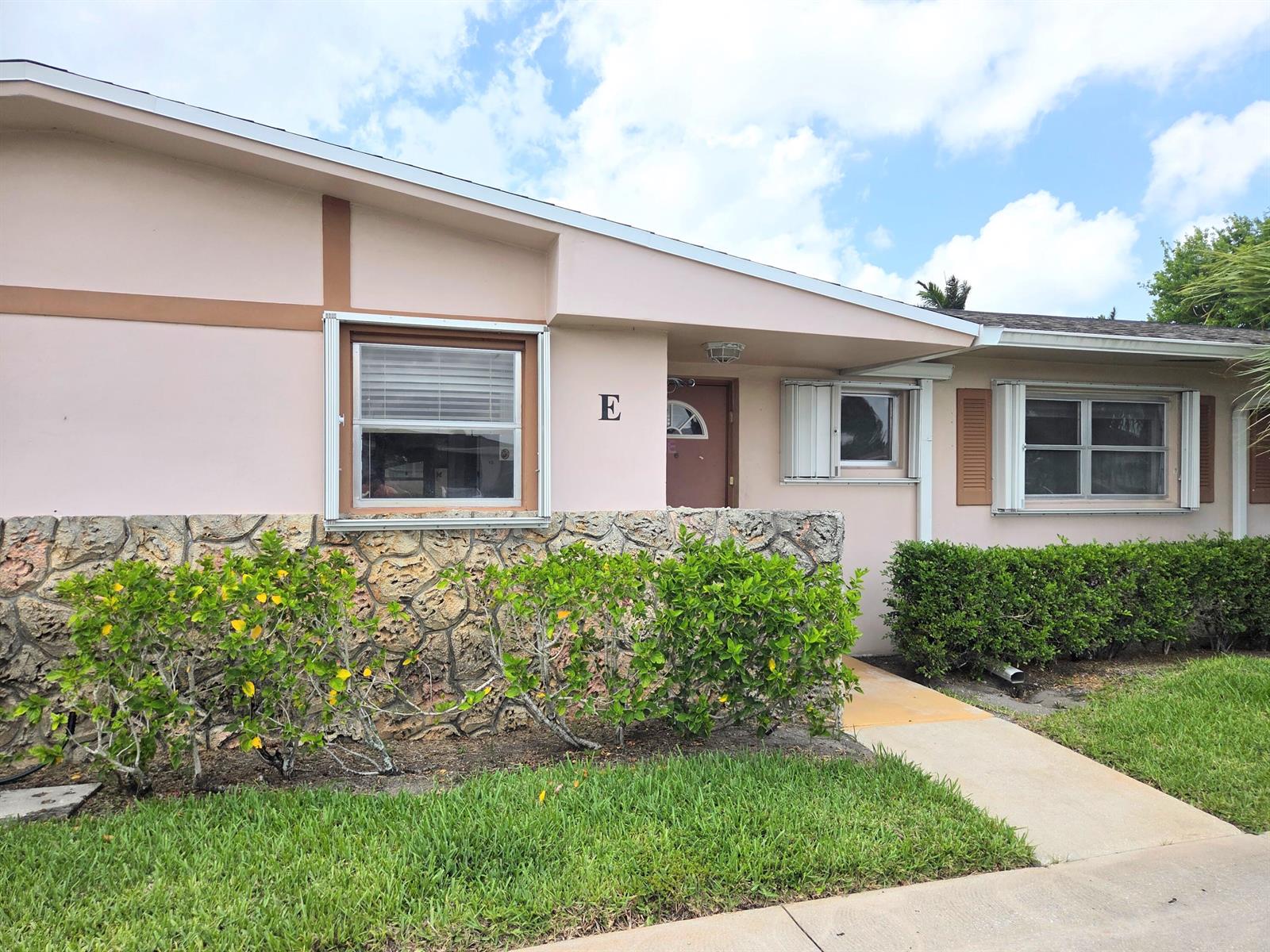 A single-story building exterior features a pink facade, stone masonry base, and a front entrance — 2703 Dudley Drive W, West Palm Beach FL 33415, WEST PALM BEACH, FL