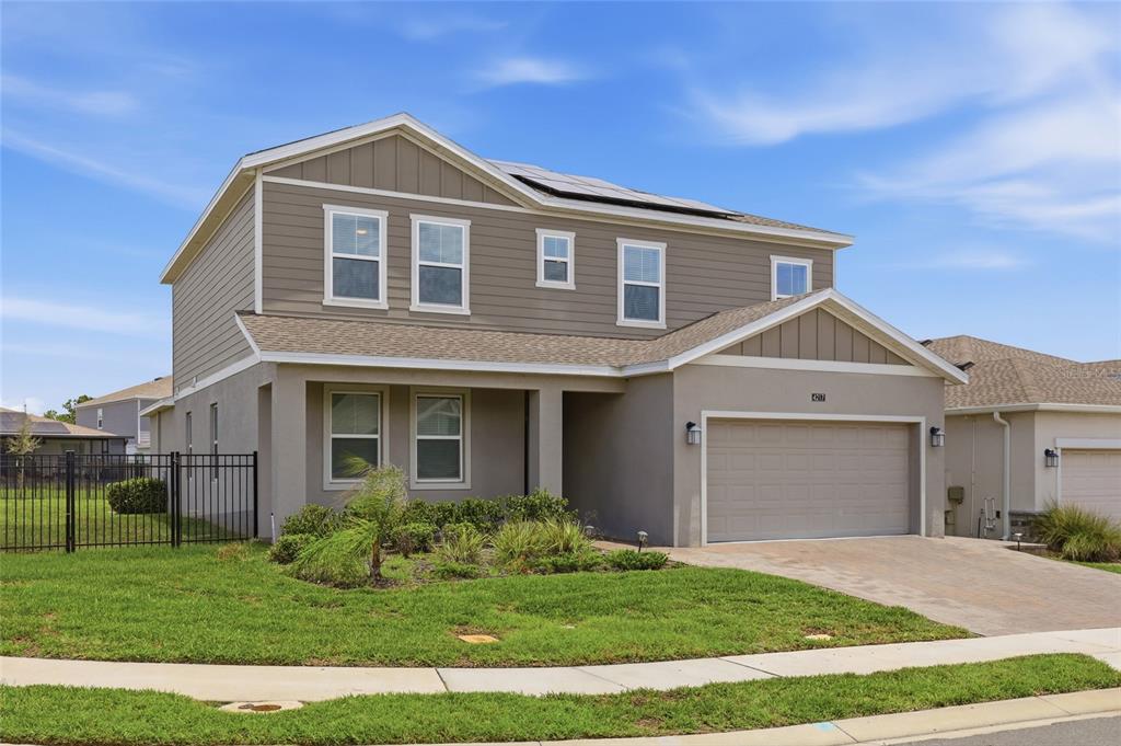 A two-story suburban house with a tan exterior, a two-car garage, and a fenced yard — 4217 EASTMINSTER ROAD, DAVENPORT, FL