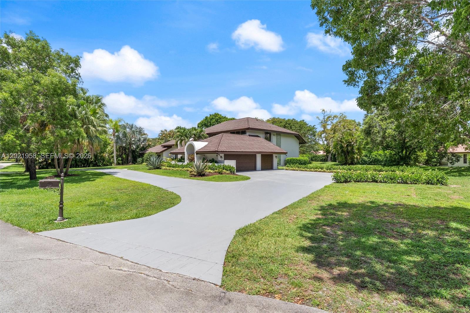 A two-story house with a brown tile roof and a large concrete driveway — 7011 Hialeah Ln, Parkland FL 33067, PARKLAND, FL