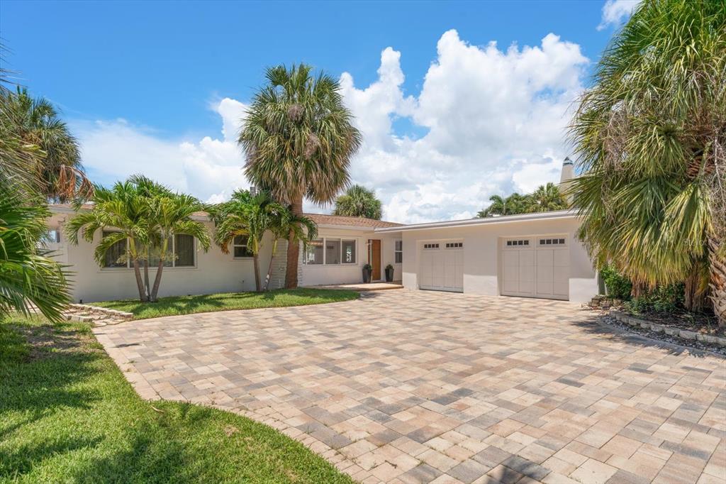 A single-story house with a paved driveway, a two-car garage, and several palm trees — 1854 VENETIAN POINT DRIVE, CLEARWATER, FL