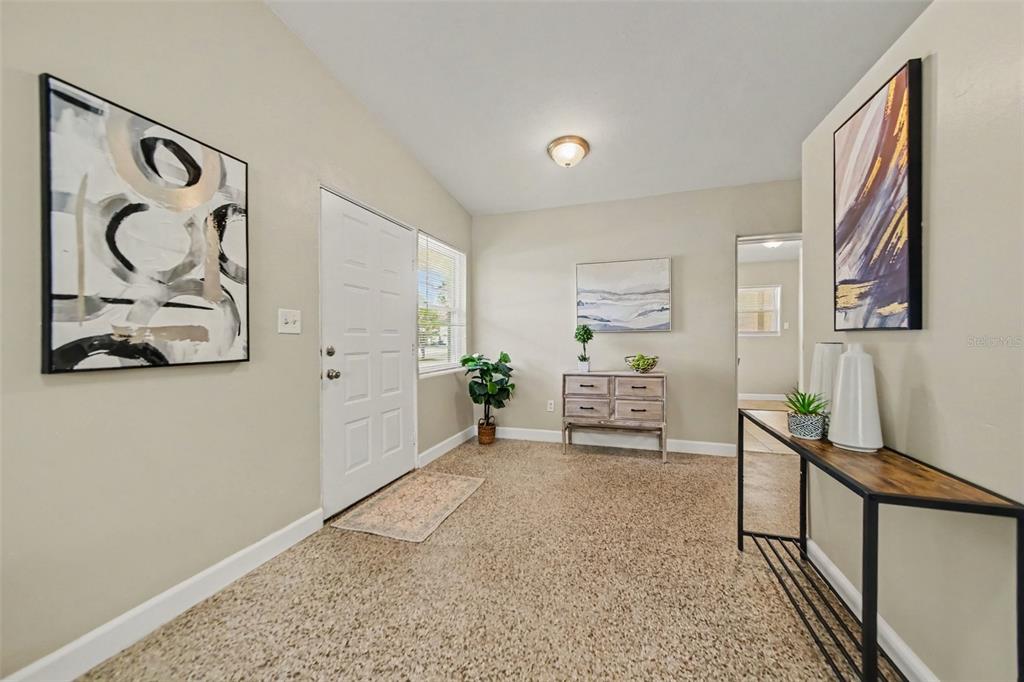 An entryway features a white front door, a console table, a small dresser, and artwork — 4965 ORANGE AVENUE, WINTER PARK, FL