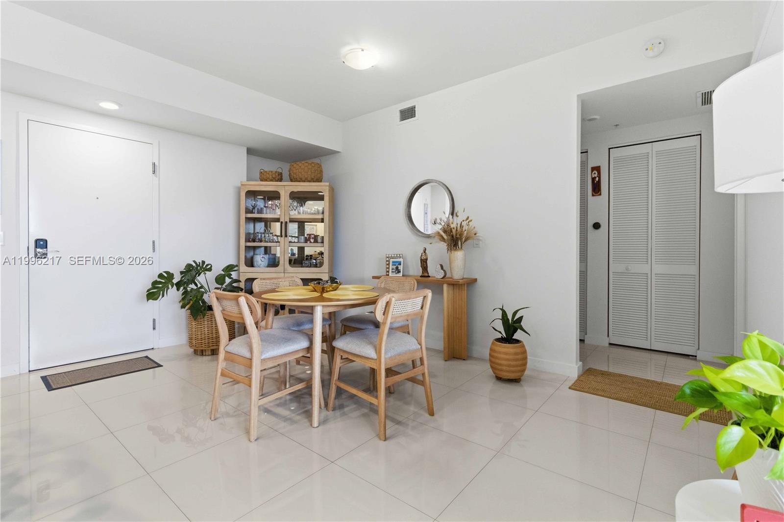 A dining area features a round wooden table, four chairs, and a glass-front cabinet — 7875 NW 107th Ave # 310, Doral FL 33178, DORAL, FL